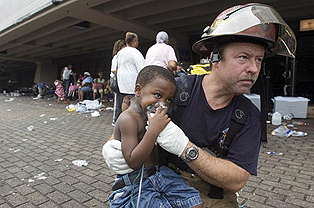 O bombeiro Doug Balser, de Nova orleans, cuida de Deonte Hurst, de 3 anos, durante a evacuação - Army Times, M. Scott Mahaskey/AP Photo