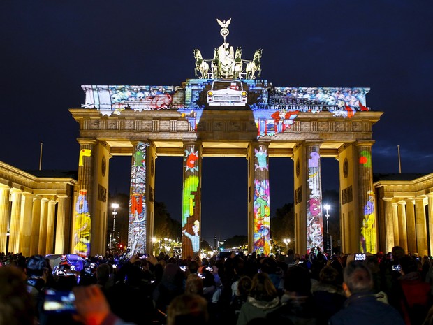 Pessoas observam uma instalação de luz no Portão de Brandemburgo durante a abertura da mostra 'Festival de Luz' em Berlim, na Alemanha. A mostra acontece até o dia 18 de outubro (Foto: Hannibal Hanschke/Reuters)