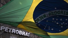 The Brazilian national flag flutters at the front of the headquarters of the Brazilian state oil giant Petrobras, in Rio de Janeiro, Brazil, on March 13, 2015. The corruption scandal enveloping Brazilian state oil giant Petrobras deepened Thursday when prosecutors said they will investigate three members of the ruling coalition, including the governor of Rio de Janeiro state. Dozens of political figures and former Petrobras executives are under suspicion over a scheme facilitating corruption and money laundering that saw an estimated $3.8 billion creamed off inflated contracts over a decade, though nobody has yet been convicted. AFP PHOTO / VANDERLEI ALMEIDA (Photo credit should read VANDERLEI ALMEIDA/AFP/Getty Images)